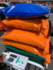 A chair scale displaying weight bags stacked on it, indicating weight measurement.