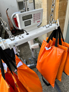 A scale displaying orange bags suspended from it, indicating weight measurement.
